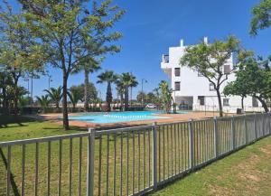 a fence around a swimming pool with a building in the background at Casa Émir in Roldán
