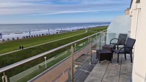 un balcone con sedie e vista sulla spiaggia di Penthaus 14 Strandvilla Therese a Norderney