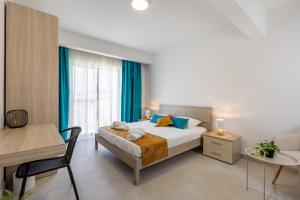 a bedroom with a bed and a table and a desk at Stylish Side Seaview Penthouse By Quicktrips in St. Paul's Bay