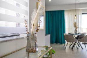 a vase with feathers in a living room at Stylish Side Seaview Penthouse By Quicktrips in St. Paul's Bay