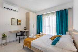 a bedroom with a large bed with blue curtains at Stylish Side Seaview Penthouse By Quicktrips in St. Paul's Bay