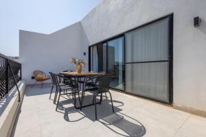 a patio with a table and chairs on a balcony at Stylish Side Seaview Penthouse By Quicktrips in St. Paul's Bay