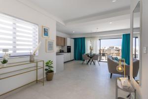 a living room with a kitchen and a dining room at Stylish Side Seaview Penthouse By Quicktrips in St. Paul's Bay