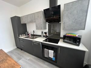 a kitchen with a sink and a stove top oven at Hull NEW Central Apartment 15 UNITS AVAILABLE in Hull +11 photos