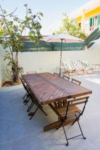 uma mesa de piquenique com guarda-sol e cadeiras em Casas Sao Luis em Faro