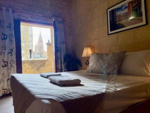 a bed with two towels on it in a bedroom at Private Pool Luxe Villa in Għajnsielem