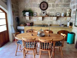 a wooden table and chairs in a kitchen at Pretty Villa & Private Pool in Għajnsielem