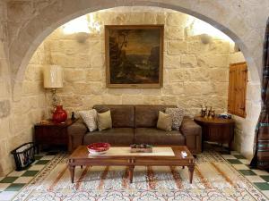a living room with a couch and a table at Pretty Villa & Private Pool in Għajnsielem
