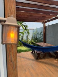 a blue hammock on a patio with a table at Bangalô Miraflores in Chapada dos Guimarães