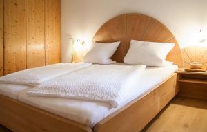 Schlafzimmer mit einem großen Bett mit einem Kopfteil aus Holz in der Unterkunft Ferienwohnungen Grimm in Nennslingen