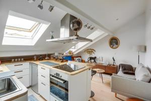 eine Küche mit Spüle und ein Wohnzimmer in der Unterkunft Le Marquiis-Versailles in Versailles