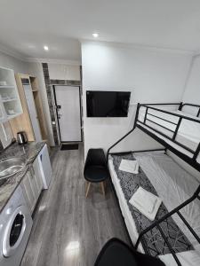a room with a bunk bed with a sink and a chair at Small House ApartHotel in Chişinău