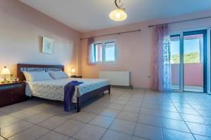 Un dormitorio con una cama y una ventana grande. en Villa Constantina Meganisi, en Meganisi