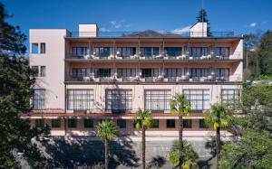 ein Gebäude mit Palmen davor in der Unterkunft Hotel Monte Verità in Ascona