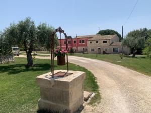 een standbeeld van een bloempot op een stenen muur naast een weg bij Richiami di Sicilia in Modica