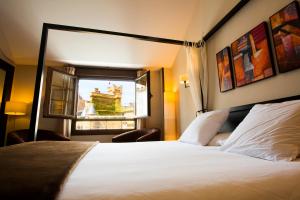 a hotel room with a bed and a window at Hostal Rural Villa Vieja in Olite