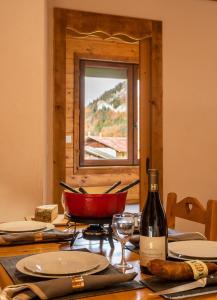 a table with a bottle of wine and a glass at Gite Balnéo La Pomme de Pin in Sixt