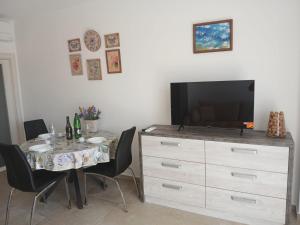 a dining room with a table and a tv on a dresser at Omega Apartments in Premantura