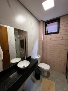 a bathroom with a sink and a toilet and a window at Pousada Casa Limão in Rifaina +27 photos
