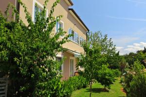 dom z drzewami przed nim w obiekcie BOŽICA House with apartments w mieście Murine