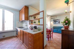 a kitchen with wooden cabinets and a blue couch at ☆ Smart and relax flat ☆ TIZIANA' S HOLIDAY HOUSE - HOMY 5 TERRE in La Spezia +9 photos