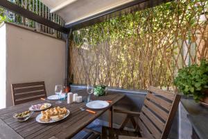 a wooden table with food and wine glasses on a balcony at ☆ Smart and relax flat ☆ TIZIANA' S HOLIDAY HOUSE - HOMY 5 TERRE in La Spezia
