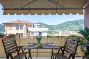 a table with a vase of flowers on a balcony at ☆ Smart and relax flat ☆ TIZIANA' S HOLIDAY HOUSE - HOMY 5 TERRE in La Spezia