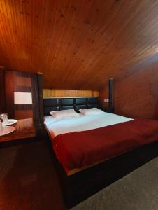 a bedroom with a large bed with a wooden ceiling at Havemore luxury stays in Solan