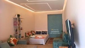 a living room with a bed and a book shelf at DeMare Suite - Nea Moudania in Nea Moudania