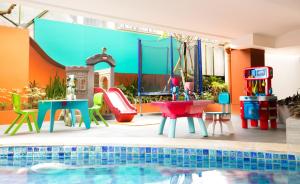 ein Pool mit farbenfrohen Möbeln neben einem Pool in der Unterkunft Siesta Legian in Legian