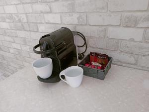 a bag and two cups on a table with a box at Apartament Mazury in Olecko +15 photos