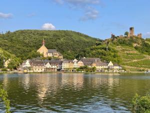 a town on a hill next to a body of water at Mosel-Wohnen II - FERIENLAND COCHEM - Ellenz-Poltersdorf in Ellenz-Poltersdorf