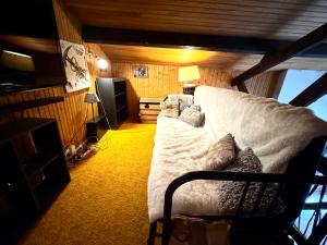 a living room with a white couch and a television at Grand chalet de charme cosy, sauna & vue de rêve in Ban-sur-Meurthe-Clefcy