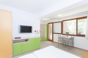 cocina con armarios verdes y mesa con TV en Apartments Kump, en Rovinj