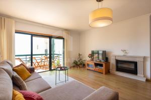 Una sala de estar con un sofá y una chimenea. en Apartamento Ouriço by ACasaDasCasas, en Ericeira