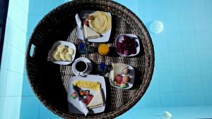 a round table with breakfast foods on it at Oka Cottage in Nusa Penida +15 photos