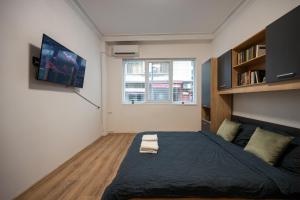 a bedroom with a bed and a tv on the wall at Martin's Treasure TOP CENTER in Sofia