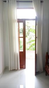 an open door in a room with a window at Ovinro Rest in Anuradhapura