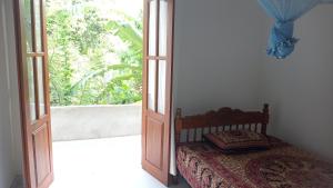 a bedroom with a bed and an open door at Ovinro Rest in Anuradhapura