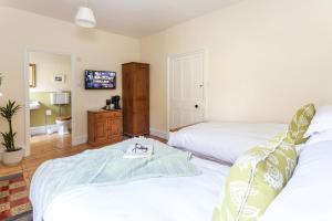 a bedroom with two beds and a tv on the wall at Haverbrack Country House in Beetham