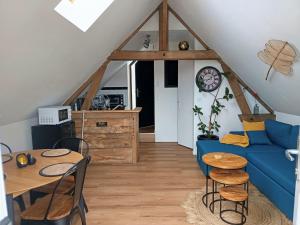 a living room with a blue couch and a table at NATURAL COSY in Honfleur