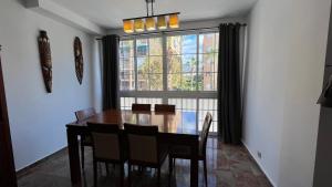 a dining room table with chairs and a large window at Apartamento en Almuñécar con piscina comunitaria in Almuñécar