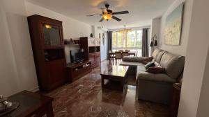 a living room with a couch and a tv at Apartamento en Almuñécar con piscina comunitaria in Almuñécar