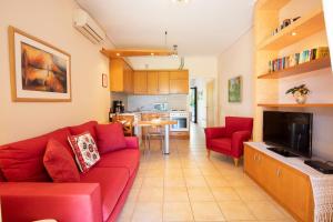 a living room with a red couch and a kitchen at Casa Solea in Barbati