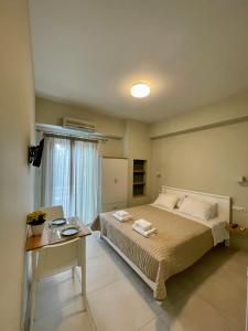 a bedroom with a bed and a desk with a laptop at Buganvillas Studios in Preveza +42 photos