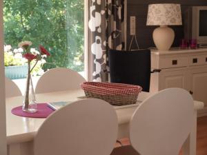 een keuken met witte stoelen en een tafel met een vaas bij Apartment Boven Jan 572 in Den Helder