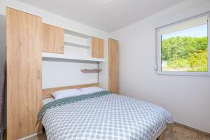 a bedroom with a bed and a window at Lara apartment for two in Skrbčići