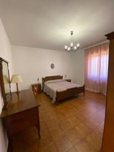 a bedroom with a bed and a table and a chandelier at Pasquina and the Val d'Orcia in Vivo dʼOrcia