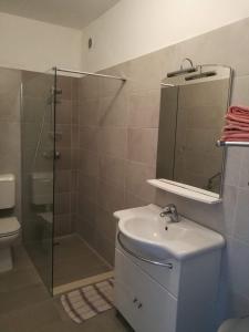 a bathroom with a shower and a sink and a mirror at On the beach apartments PAG in Dinjiška +46 photos