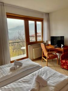 a hotel room with two beds and a desk and a window at Goldenhof in Auer